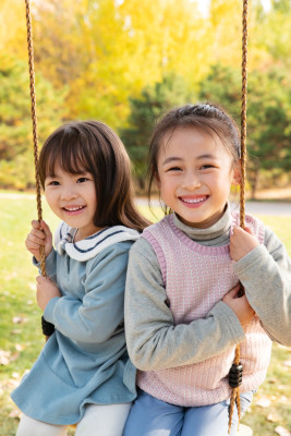 两个女孩在公园里荡秋千