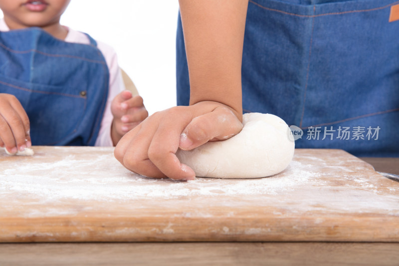 大人在砧板上和面孩子在一旁观看