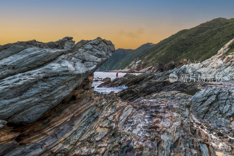海边岩石与远处人物景观