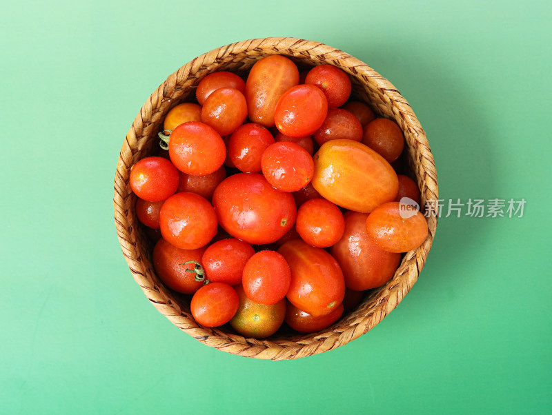 绿色背景上的一篮子新鲜瓜果西红柿番茄