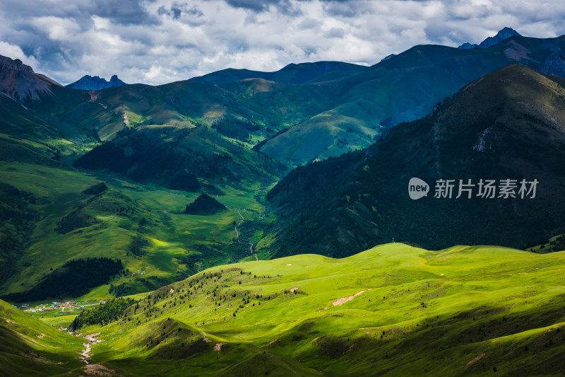 蓝天白云下广袤草原与连绵山峦自然风景