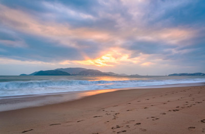 越南芽庄滨海海岸沙滩浪花与日出天空云彩