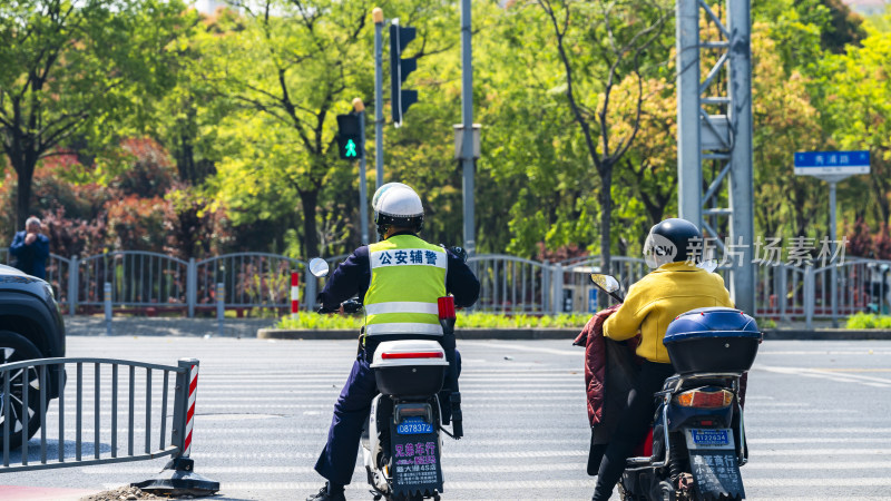 公安辅警路口骑摩托执勤