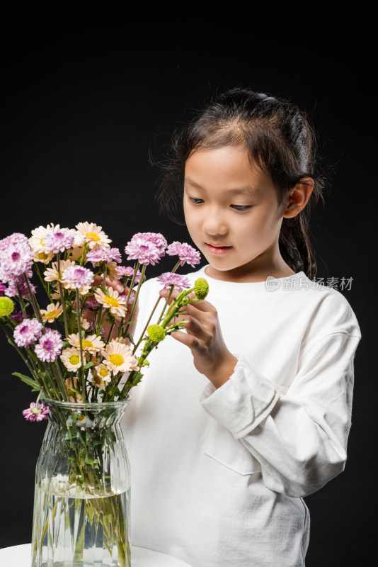 在黑背景前插花的亚裔女孩