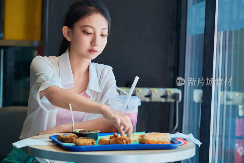 在商场快餐厅大吃特吃的中国可爱少女人像