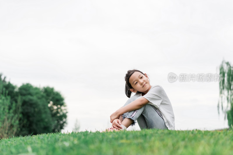 夏天坐在草地上的中国女孩