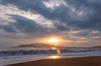 越南芽庄滨海海岸沙滩浪花与日出天空云彩