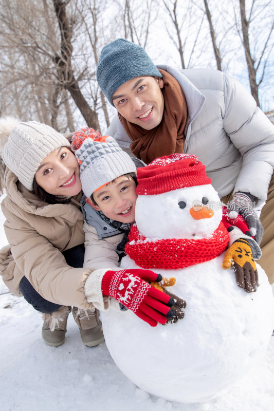 一家三口在雪地里堆雪人