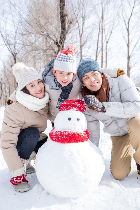 一家三口在雪地里堆雪人