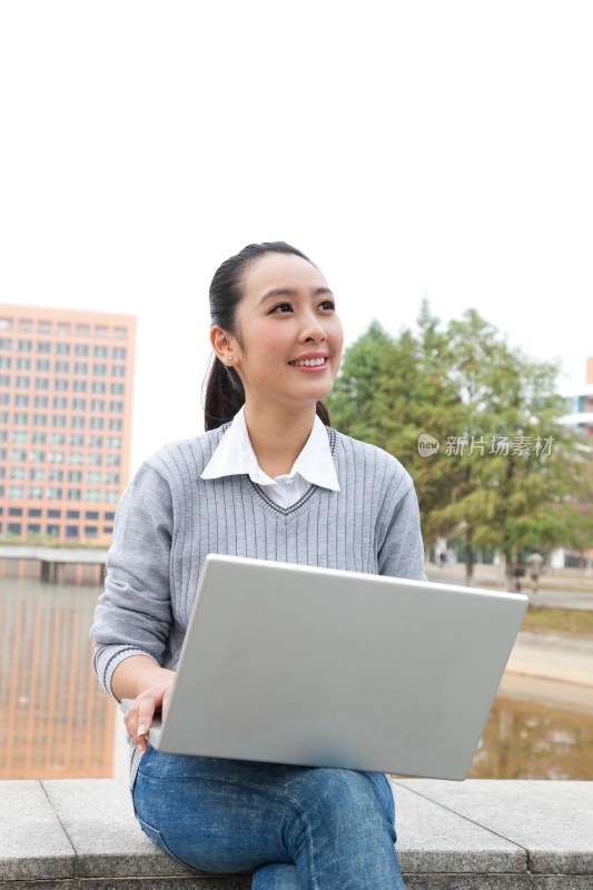 年轻大学生在校园里使用笔记本电脑