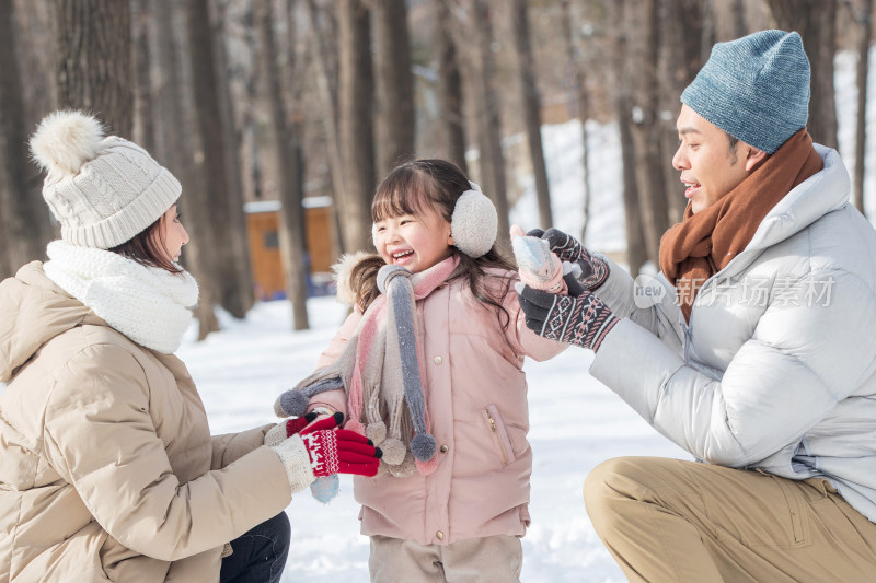 一家三口在雪地里玩耍