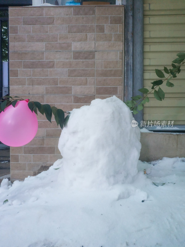 户外的积雪堆和粉色气球