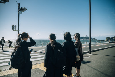 女生在镰仓海边街道结伴同行