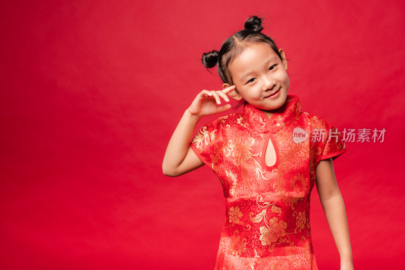 站在红色背景前穿喜庆服装的中国女孩