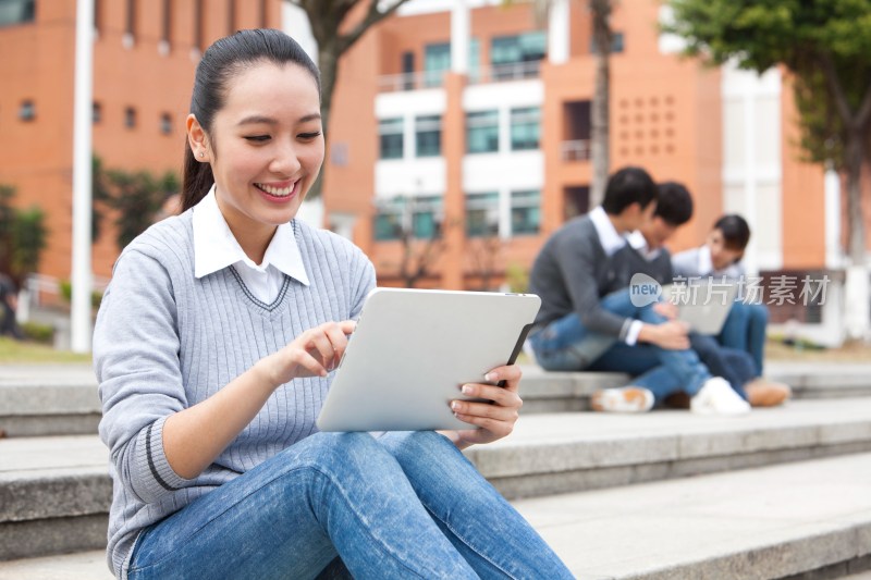 年轻大学生在校园里使用平板电脑