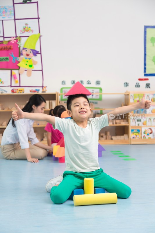 幼儿园儿童坐在地板上玩彩色积木