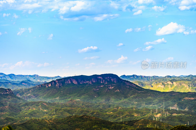 夏季山峦蓝天白云与大风车风力发电