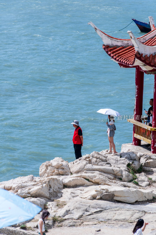 海边亭旁游客赏景