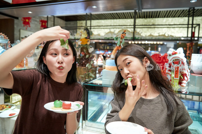 在酒店自助餐厅大吃特吃的亚洲可爱闺蜜少女