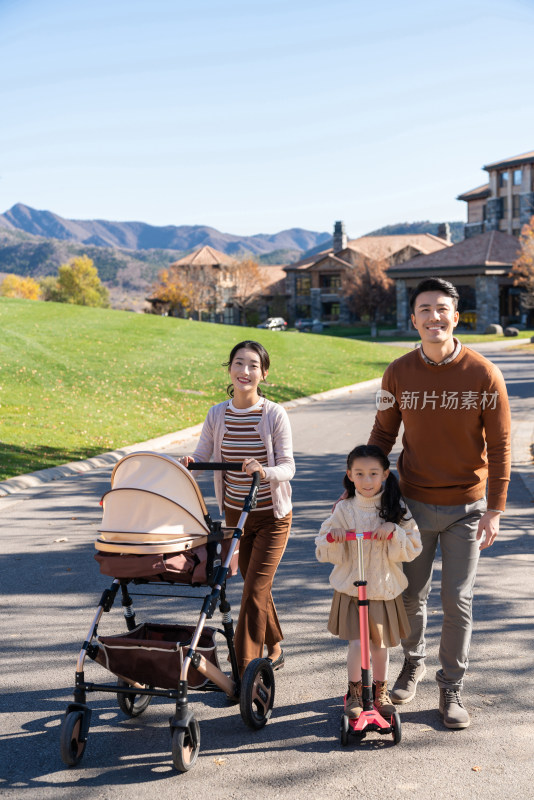 年轻夫妻推着婴儿车散步