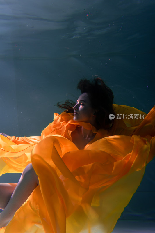 女性水下身着黄色长裙漂浮