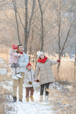 快乐家庭在雪地里散步