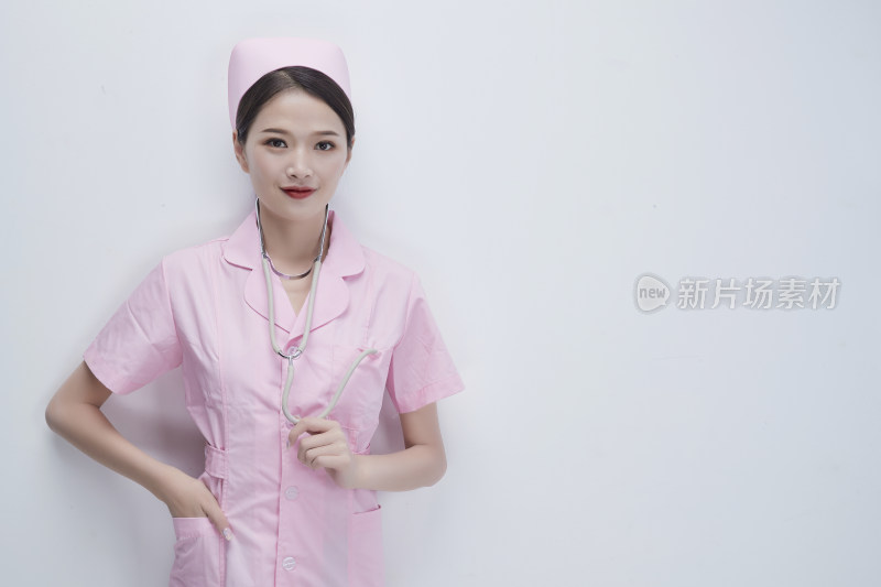 身穿粉色护士服佩戴听诊器的女性医护人员