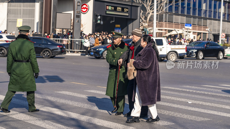 穿军大衣的军人搀扶老人过马路