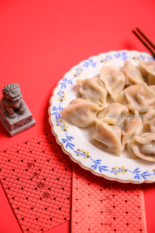 红色背景中国北方春节美食饺子与新年红包