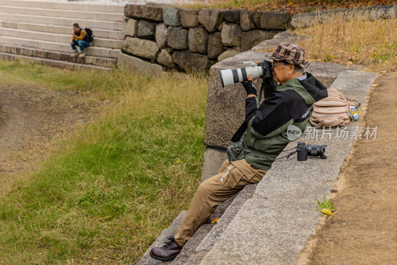 大阪城公园里拍摄秋叶的摄影师