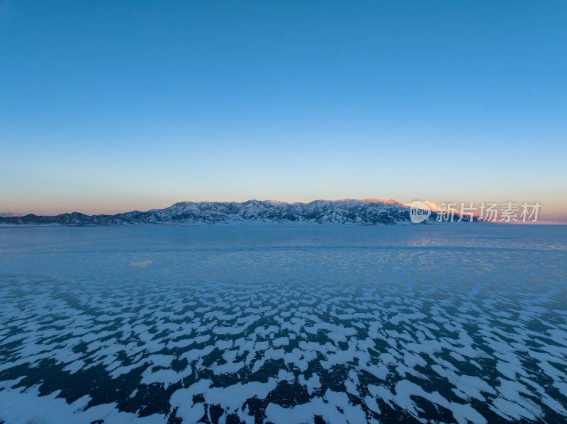 新疆冬季赛里木湖雪景雪山冰湖蓝冰日照金山