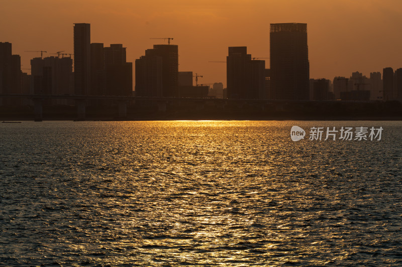 水边城市的落日余晖映在水面上的景象