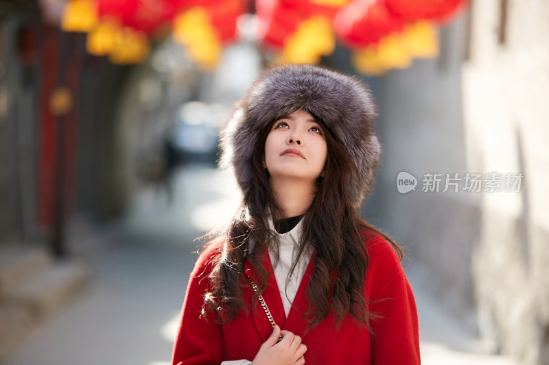 春节在老城古巷穿着喜庆服饰的美丽少女