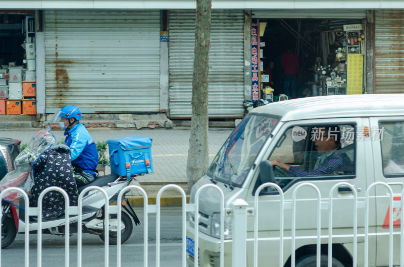 街道上的外卖骑手与面包车