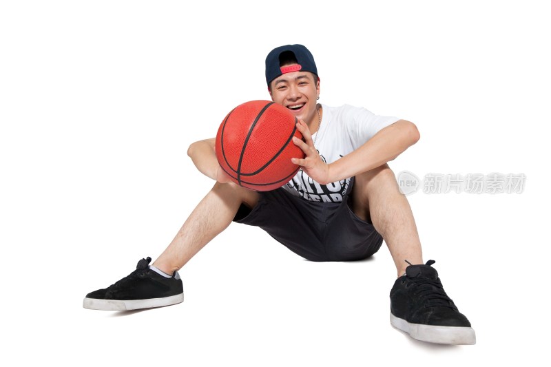 棚拍年轻男人坐在地上玩篮球
