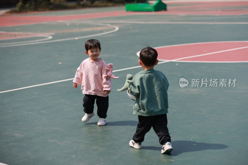 一对双胞胎在篮球场玩耍