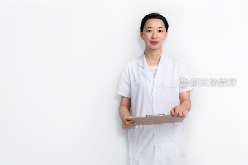 白色背景前拿着病例夹的中国年轻女性医生