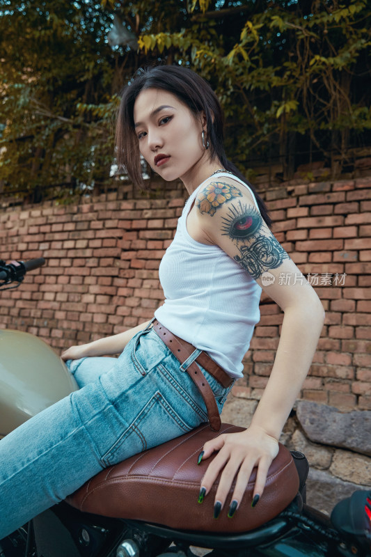 骑在复古摩托车上的时尚亚洲少女