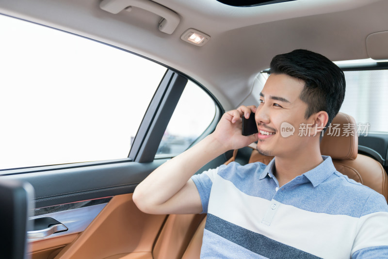 商务男士坐在车里使用手机