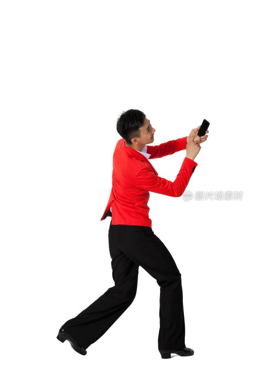 棚拍穿红色西装的年轻男人拿着手机跳舞
