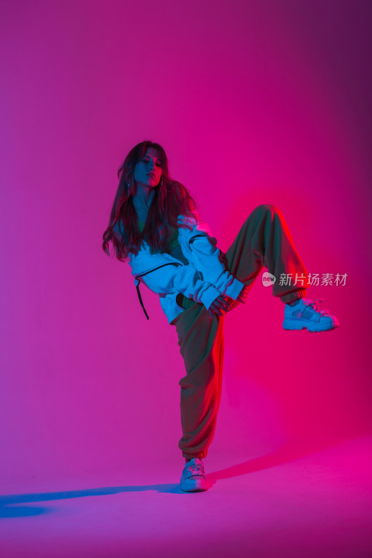 女性在粉紫色背景下跳舞