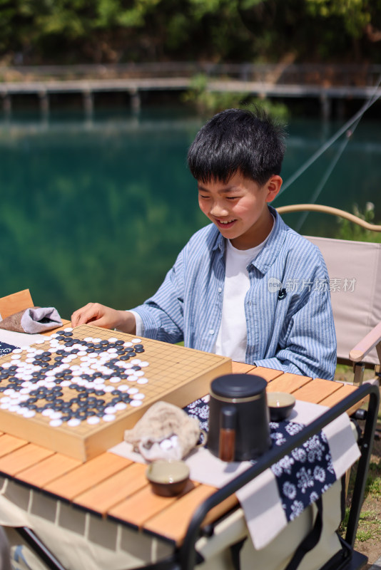 正在野外下棋的中国小男孩