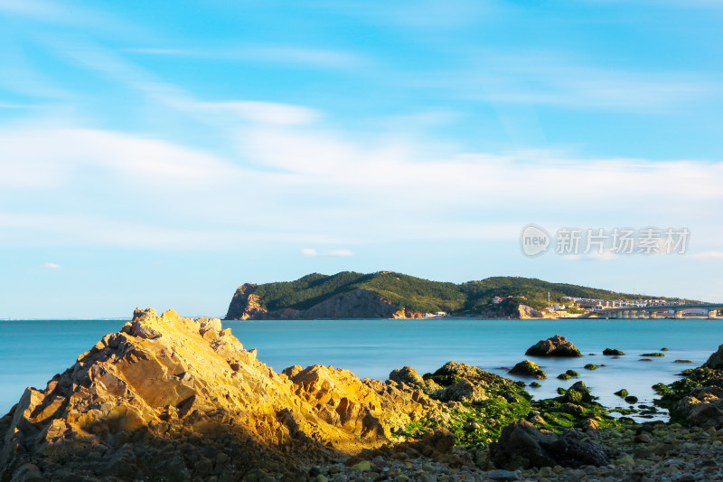 海边岩石风景与远处山峦的自然景观