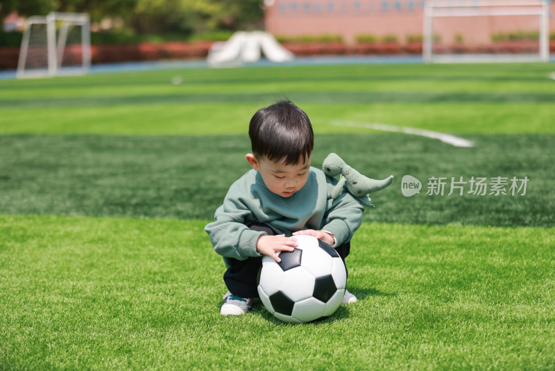 可爱的男孩在足球场上玩耍
