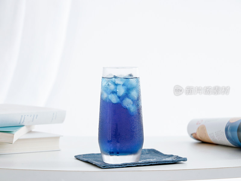 白色桌面上的一杯夏日蓝色饮品