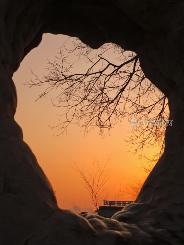 透过石洞看夕阳与枯树