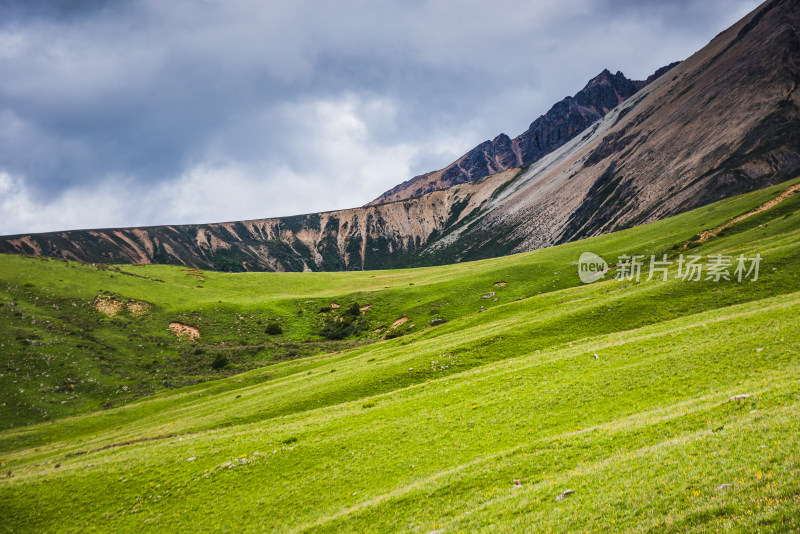 蓝天白云下广袤草原与连绵山峦自然风景