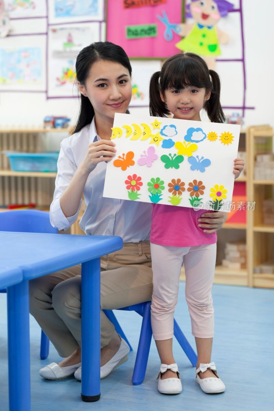 幼儿园女老师和儿童展示手工儿童画