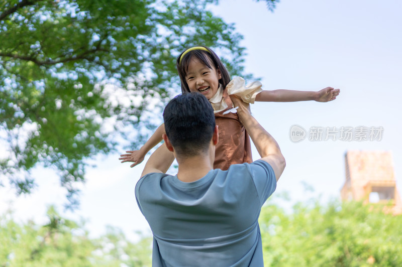 爸爸抱起女儿张开双臂转圈旋转