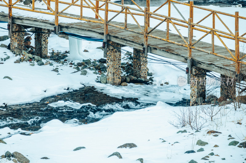 东北冬季雪地河流上的小桥